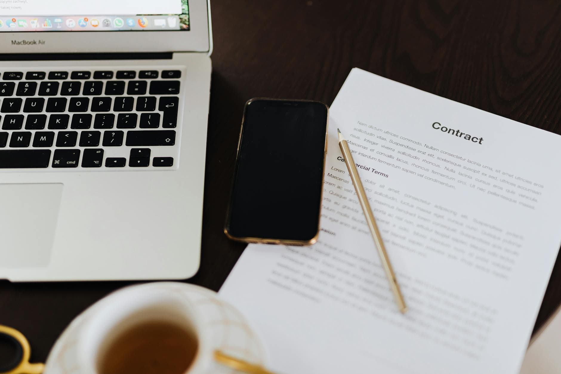 Workspace with an open annotation services contract, laptop, and notes – capturing the SLA, IP ownership, rework, and data-deletion clauses an outsourcing buyer should negotiate